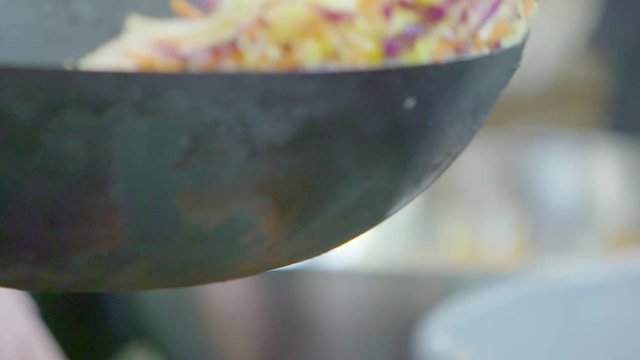 Mixing a stir fry vegetable wok dish in slow motion