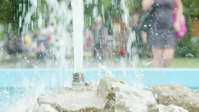 Slow motion shot of an artesian water fountain in the summer. Public park