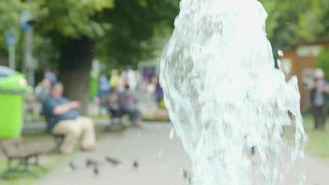 Slow motion shot of an artesian water fountain in the summer. Public park