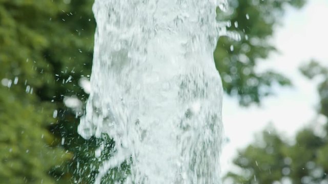 Slow motion shot of an artesian water fountain in the summer. Public park