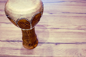 Traditional Tunisian drum made of clay and camel skin. Clay drum with leather membrane on a wooden...
