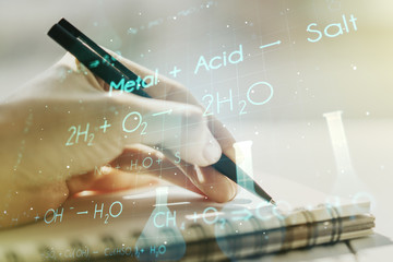 Creative chemistry concept with woman hand writing in notebook on background. Multiexposure