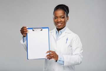 medicine, profession and healthcare concept - smiling african american female doctor or scientist in white coat with clipboard over grey background