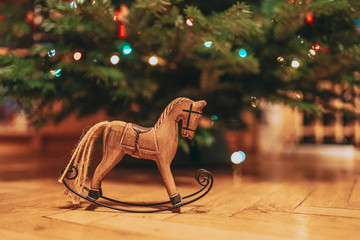 Wood horse Christmas decorative underneath a Christmas tree