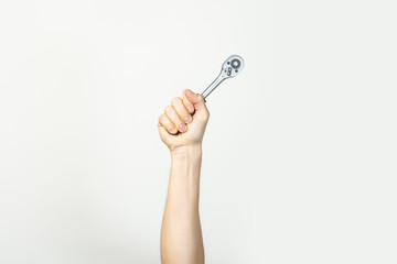 Male hand holds a wrench on a light isolated background. Concept plumber, auto repair, vulcanization. banner