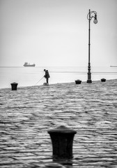 Fisherman at the harbor of Trieste in black and white