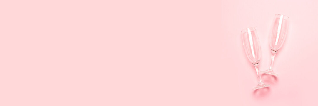 two empty champagne glasses on a pale pink background. The concept of a wedding, birthday, anniversary, party, bachelorette party. Banner