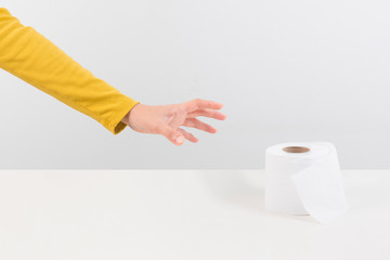 Woman holds a roll of tissue in hands isolate on a white background.  during Coronavirus outbreak or Covid-19, Concept of Covid-19 quarantine. Dangerous COVID virus, Doomsday panic people panic.