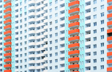 Fototapeta na wymiar Bright blue construction wall with orange balconies