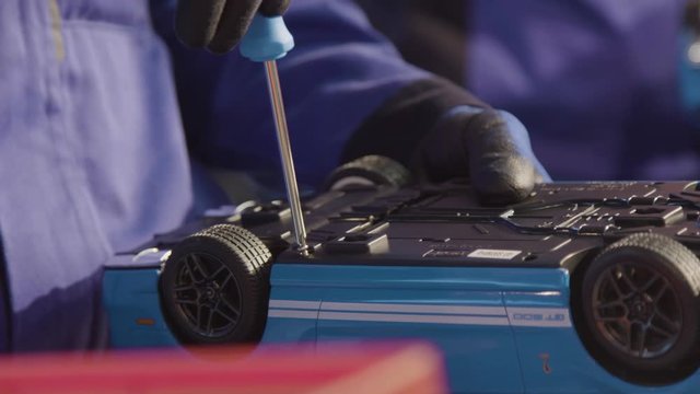 Close up of factory workers building toy cars for kids. Assembly line