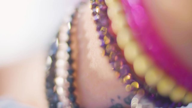 Close up shot of an attractive young woman's wrist wearing colorful bracelets