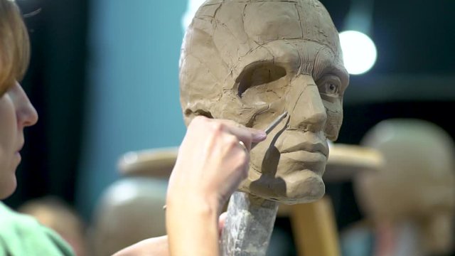 Sculptor at work. The process of creation an ecorche, a sculpture of a human head with the skin removed to display the musculature and bones.