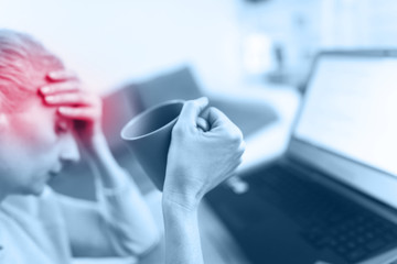 Fototapeta premium Woman feeling unwell, headache while working on a laptop.