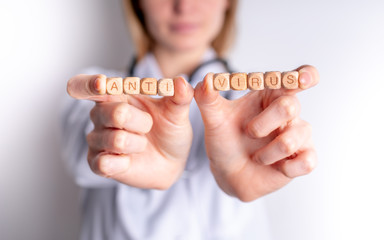 Antivirus concept wooden blocks in hand of female doctor