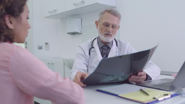 Surgeon looking at x-ray image, consultation with doctor in clinic, diagnostics