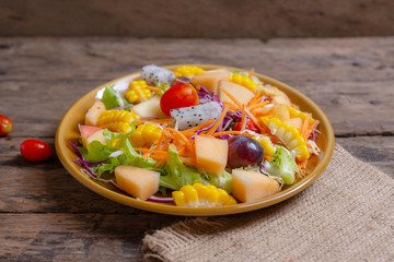 Fruits salad and vegetable in dish plate on wooden table