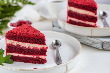 Cake Red velvet on two white plates, two servings. On a light background. Birthday, holidays, sweets.
