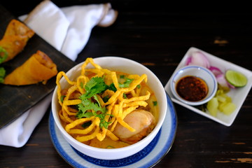 Khao soi with chicken on wood table background 