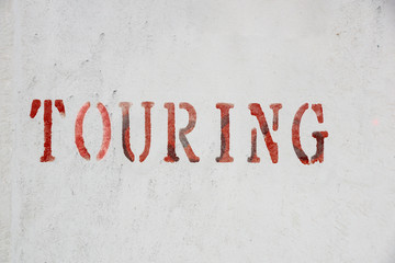 touring sign written on wall . close up