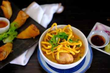 Khao soi with chicken on wood table background 