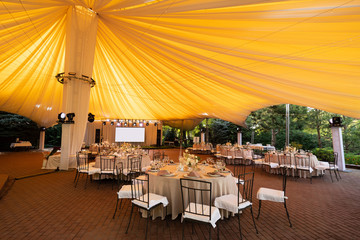 tables in outdoor tent day. Wedding decor. 