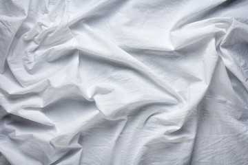 wrinkled white cotton sheet with large folds as background