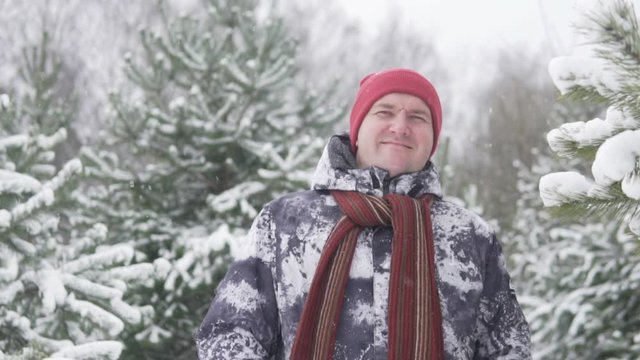 A fat man stands in a snowy forest. March in Russia