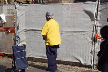Back view of young man walking at city street in Europe at morning