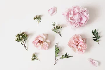 Poster Decorative floral composition with pink roses, peonies, chameleucium flowers and green leaves on white table background. Flower pattern. Flat lay, top view. Wedding or birthday styled stock photo. © tabitazn