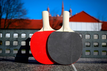 Rackets for table tennis.  Outside.  There is a place for text, copy space.  The concept of sport, healthy lifestyle.