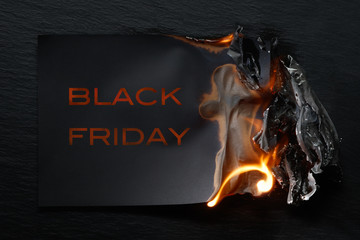 Burning piece of black paper with the word 
