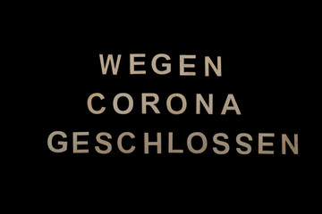Fototapeta na wymiar Überschrift „Wegen Corona geschlossen“ auf dunklem Hintergrund