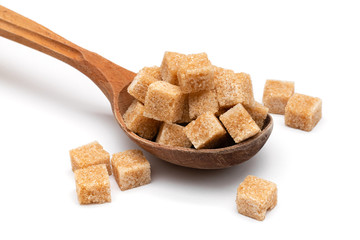 brown refined sugar in a wooden spoon on a white background
