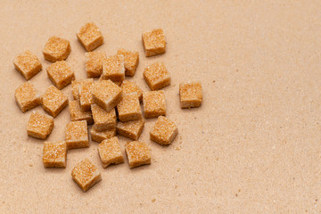 Fototapeta na wymiar brown refined sugar cubes on craft paper background