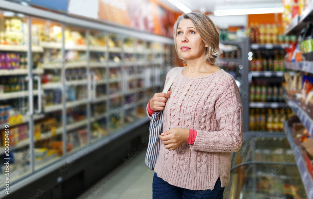 Wall mural woman visiting supermarket food department