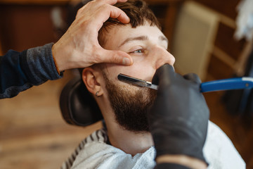 Barber with razor, old school beard cutting