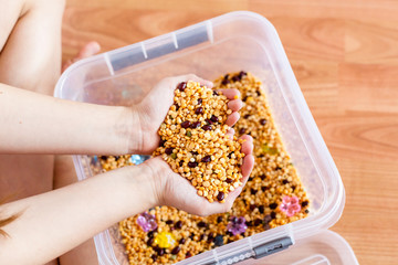 container with cereals, materials for children's development, fine motor skills, logic and memory, mind, girl develops, games with sand, child development, childhood, preparation for school,Montessori