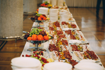 a lot of cold snacks and drinks on buffet table, catering