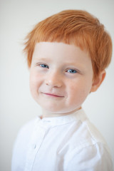 Funny red-haired boy in a white shirt
