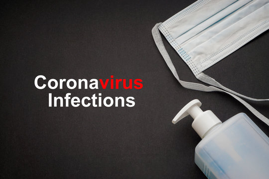 CORONAVIRUS INFECTIONS text with antibacterial soap sanitizer and protective face mask on black background. Covid-19 or Coronavirus Concept
