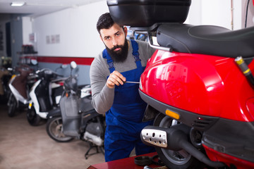 Fototapeta na wymiar Worker fixes the motorbikes components