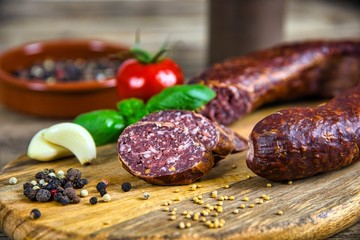 Smoked salami homemade with spices on a rustic wooden background