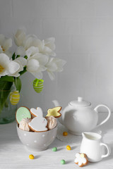 Easter table setting with gingerbread bunnies, eggs and flowers. Happy Easter Greeting Card Template. Easter cake and colorful eggs on festive table. The concept of family celebration. Easter holiday.