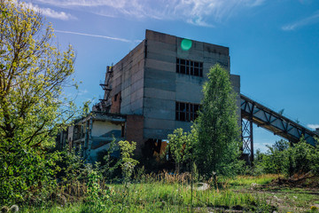 Fototapeta na wymiar Old overgrown abandoned factory of reinforced concrete