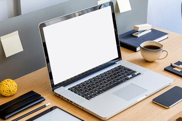 Modern business composition on the wooden desk with mock up laptop screen, tablet, notes, mobile phone, cup of coffee and office supplies in stylish concept of home decor.