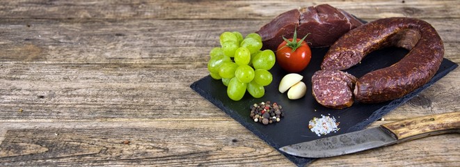  Smoked salami homemade with spices on a rustic wooden background - top view with free space for your text
