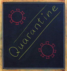 The word quarantine is written in colored crayons by hand and viral particles of coronovirus are...