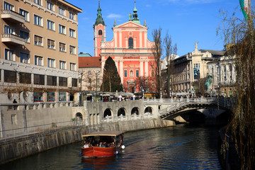 Naklejka premium Lubiana / Slovenia - December 8, 2017: View of Lubiana river with a tourist boat, Lubiana, Slovenia