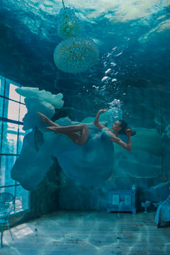 Beautiful woman in room underwater