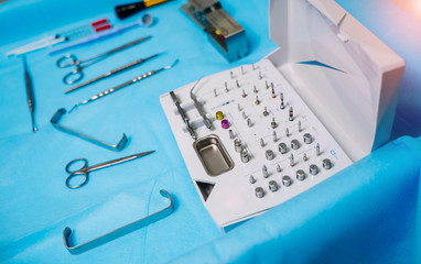 Fototapeta premium Set of dentist tools on table. Dentist mirror, forceps curved, explorer curved, dental explorer angular and explorer curved with chip, right. Dental hygiene and health concept.